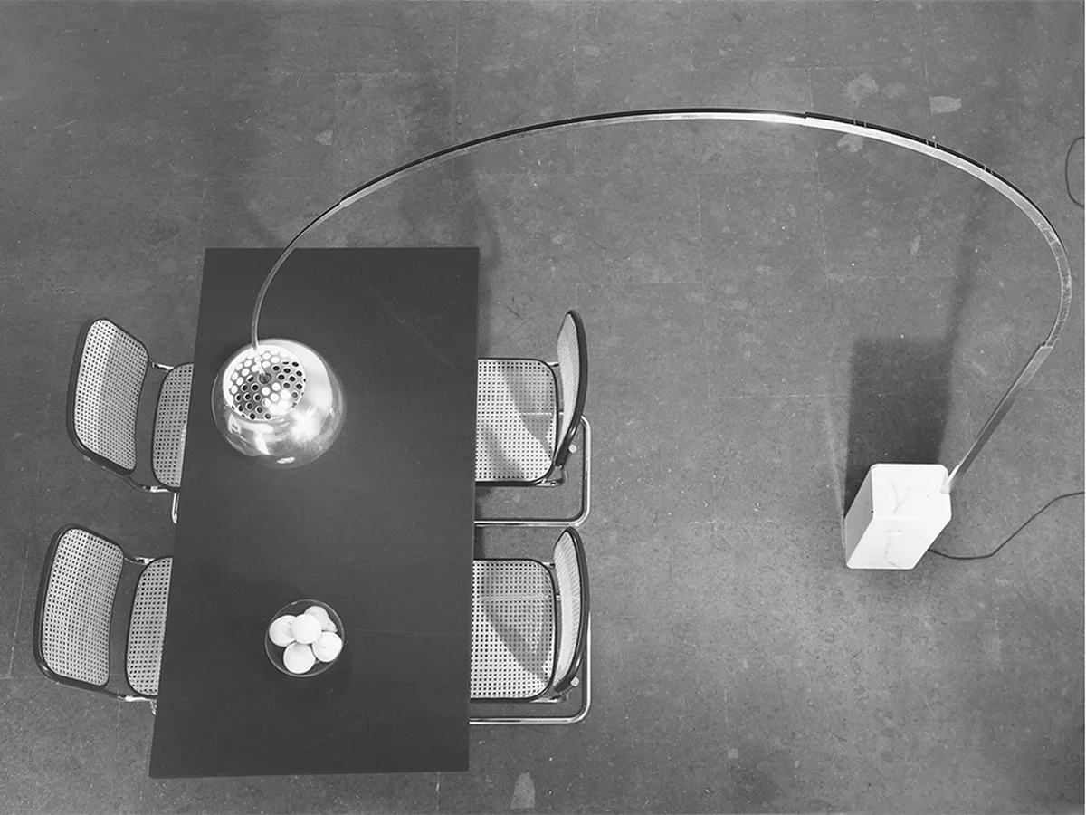 Overhead view of Arco Led spanning a dining table, marble base and perforated dome visible