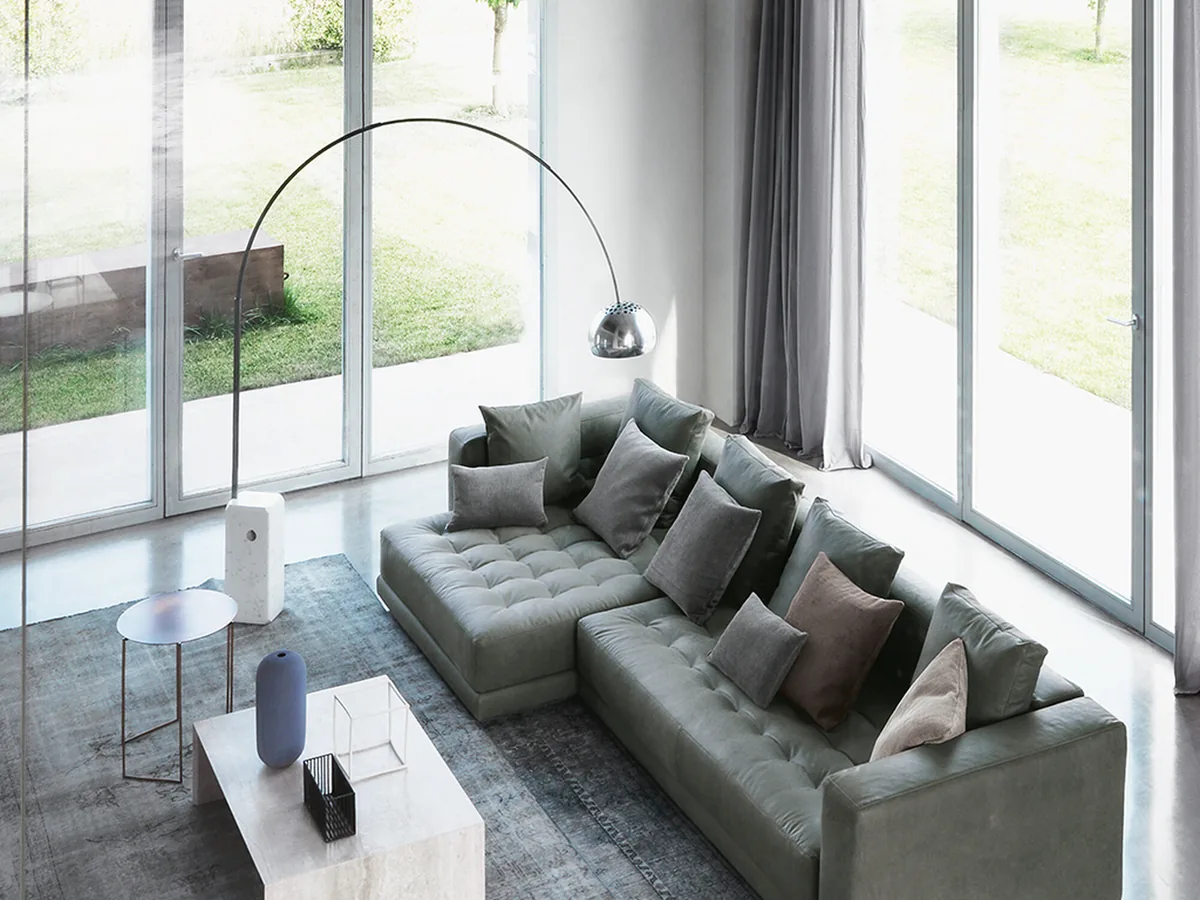 Arco Led arching over a living seating group, Carrara base on stone flooring