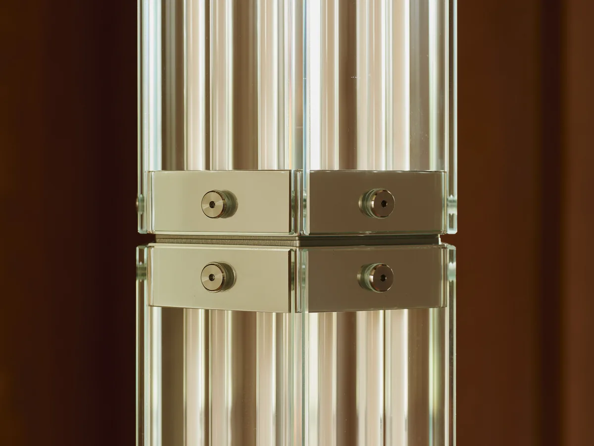 Detail of SuperWire F — polished metal joinery between hexagonal glass modules and visible filament LEDs